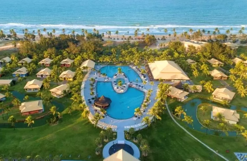 vista aérea de árvores, bangalôs e piscinas de vila galé, um dos melhores resorts all inclusive do brasil, localizado em frente à praia em cumbuco