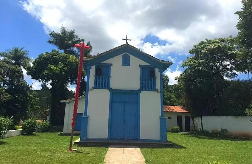 igreja azul e branca cercada de arvores, durante o dia, em macacos, destino que fica perto de belo horizonte