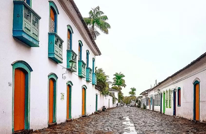 casarões brancos com portas e janelas coloridas, durante o dia, em rua de paraty, um dos melhores lugares para viajar de motorhome no brasil