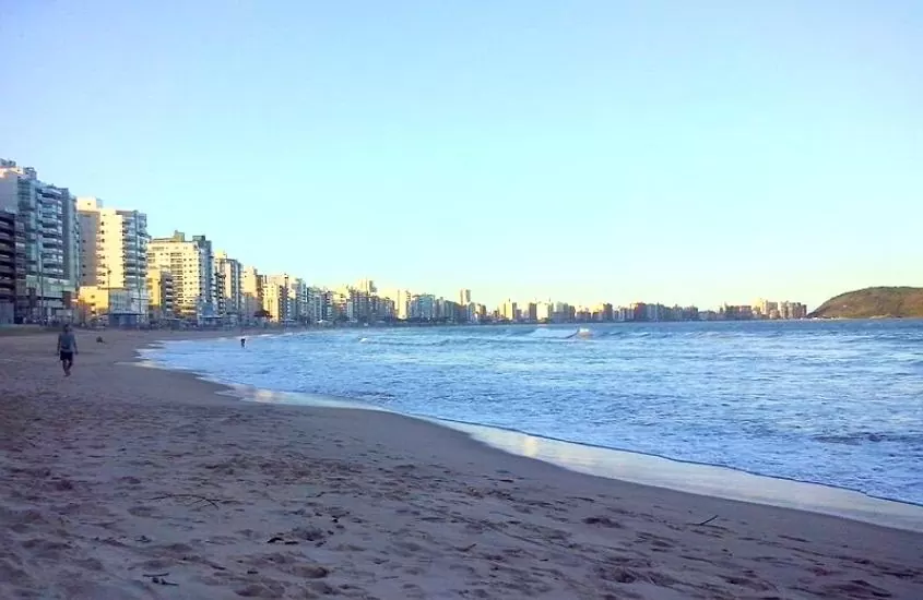 pessoas caminham, durante o dia, em praia de guarapari, um dos melhores lugares para viajar de motorhome no brasil