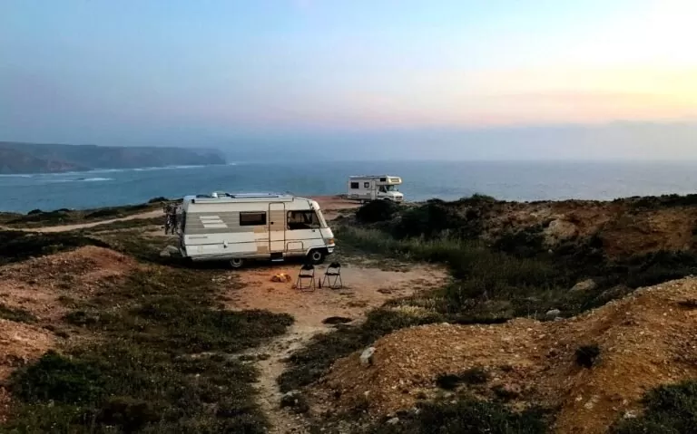 motorhome acampado na beira de montanha com vista para o mar ao pôr do sol durante uma viagem de motorhome pelo Brasil