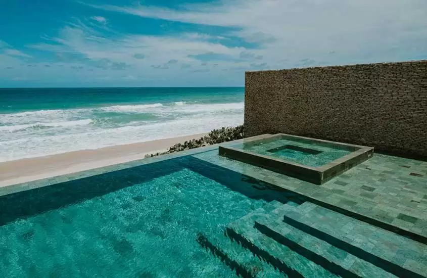 durante dia ensolarado, piscina com vista para o mar em um dos melhores resorts pé na areia do nordeste