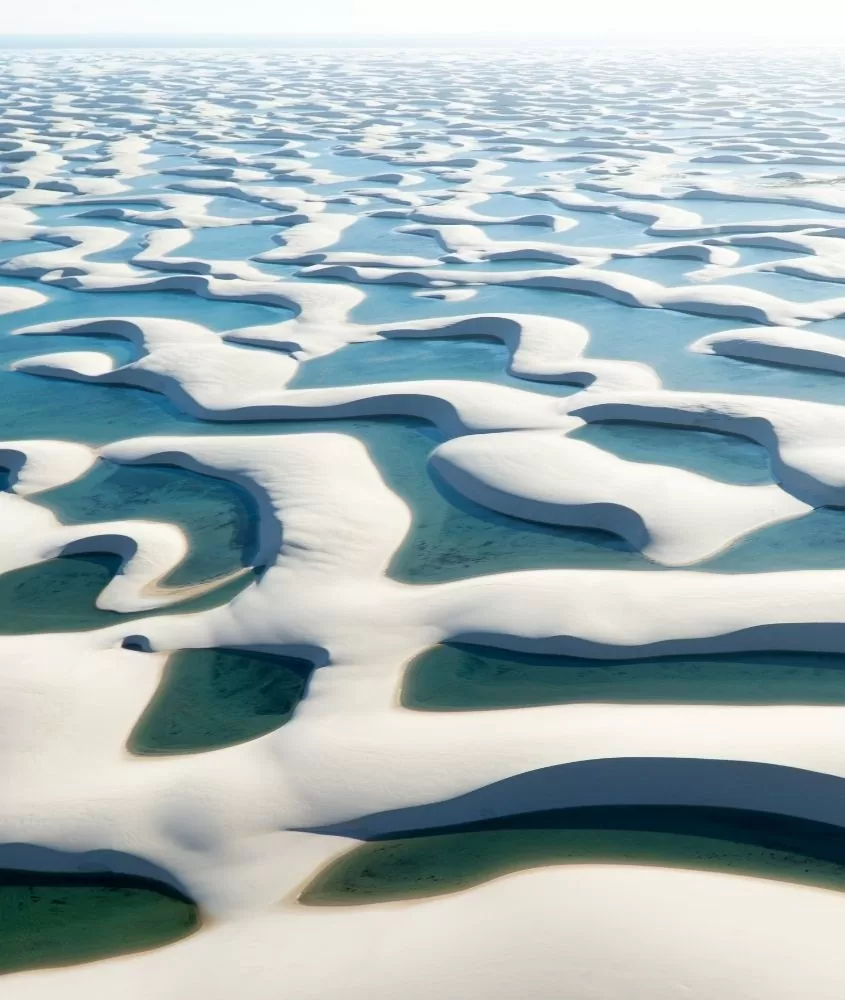 vista aérea, durante o dia, de lagoas e dunas, durante sobrevoo, que é dos melhores passeios nos lençois maranhenses