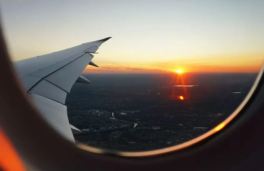 vista do pôr do sol da janela de um avião, uma opção para quem quer saber como ir de bangkok para krabi de forma rápida