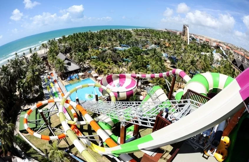vista aérea de toboaguas, piscinas, árvores e praia ao fundo, durante dia ensolarado em Beach Park, um dos melhores lugares para viajar com crianças no brasil