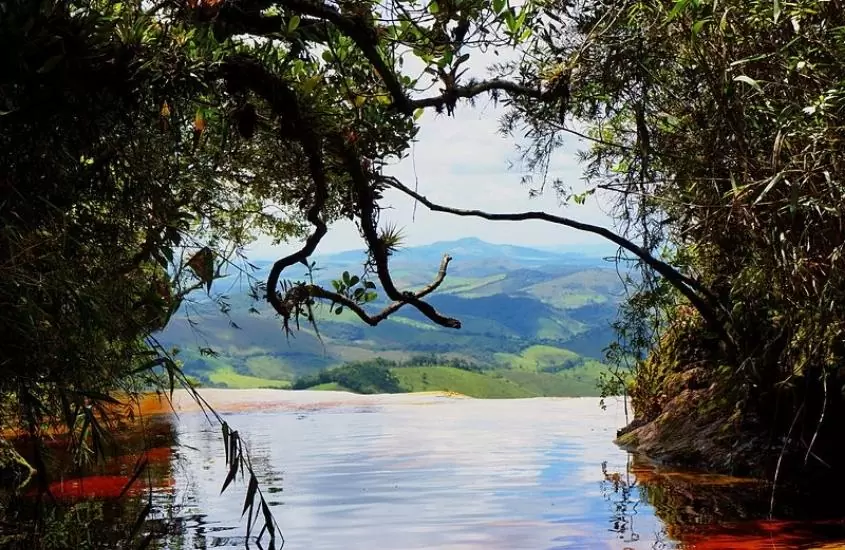 árvores e piscina natural com vista para as montanhas de ibitipoca, durante o dia