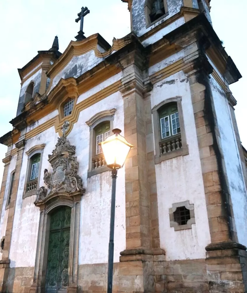 vista de baixo para cima de igreja branca e amarela, conhecida como igreja são francisco de assis, durante o dia em diamantina mg
