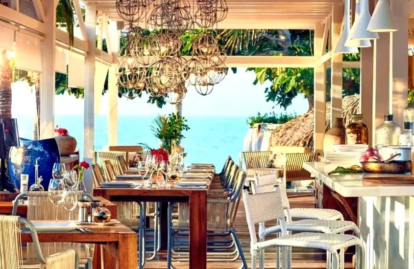 cadeiras e mesas em restaurante com vista para o mar em The Chili Beach Private Resort, um dos hotéis em jericoacoara de 5 estrelas