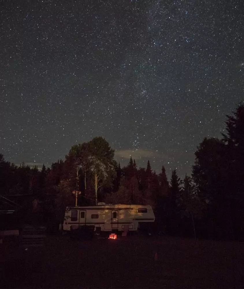 motorhome estacionado em camping, sob céu estrelado