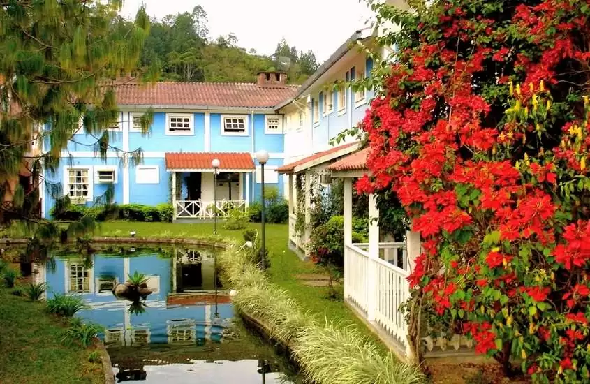 casas azuis cercada de árvores em frente a lago, em penedo, durante dia nublado