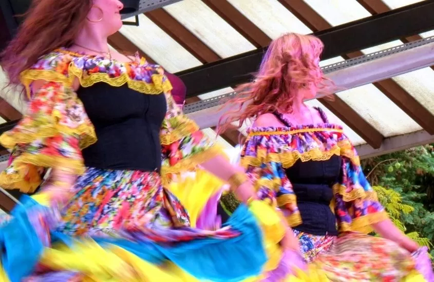 mulheres dançando com roupas coloridas durante Festival internacional de Folclores, um dos principais passeios em nova petrópolis