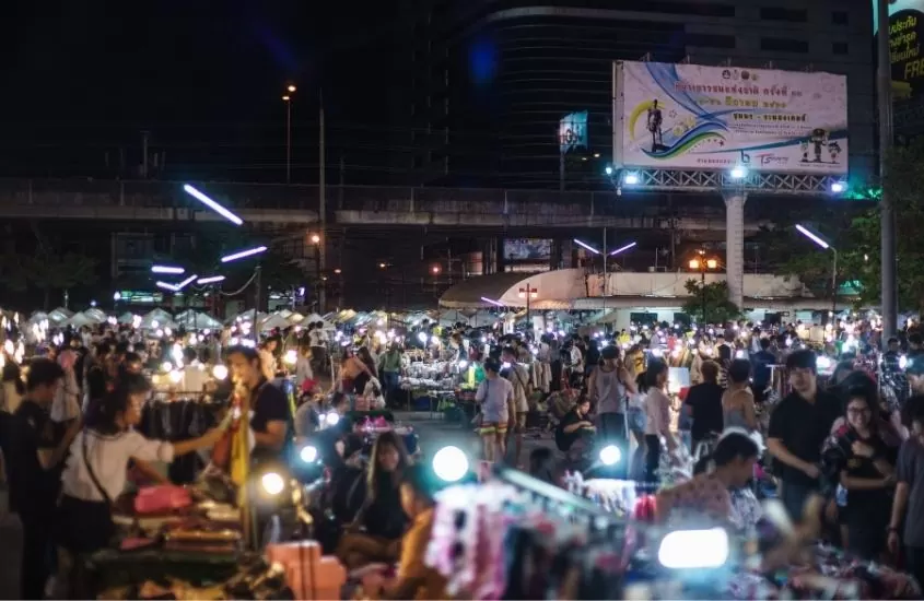 pessoas fazendo compras em barracas de mercado noturno da tailândia