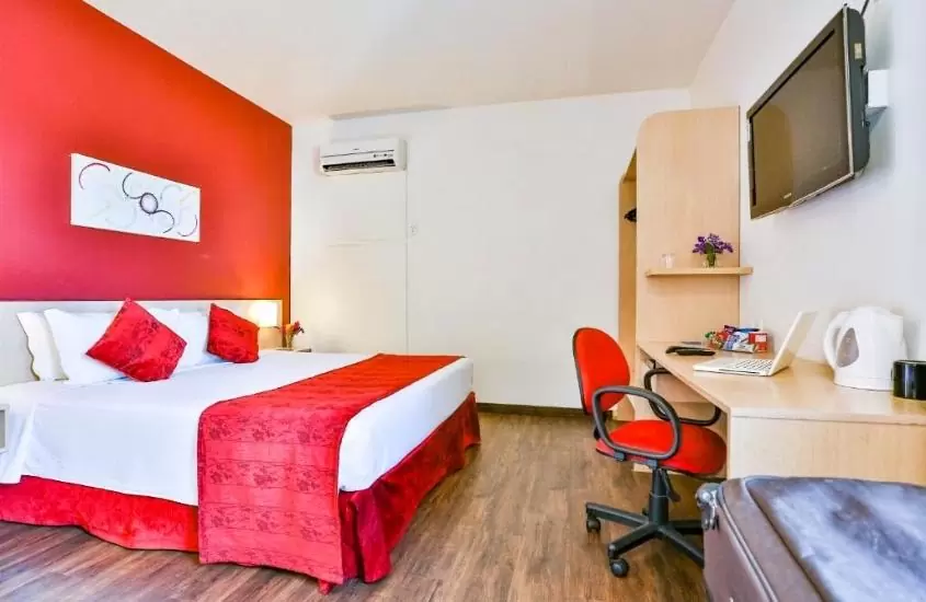 cama de casal, cadeira e mesa de escritório em suíte de Comfort Hotel Joinville