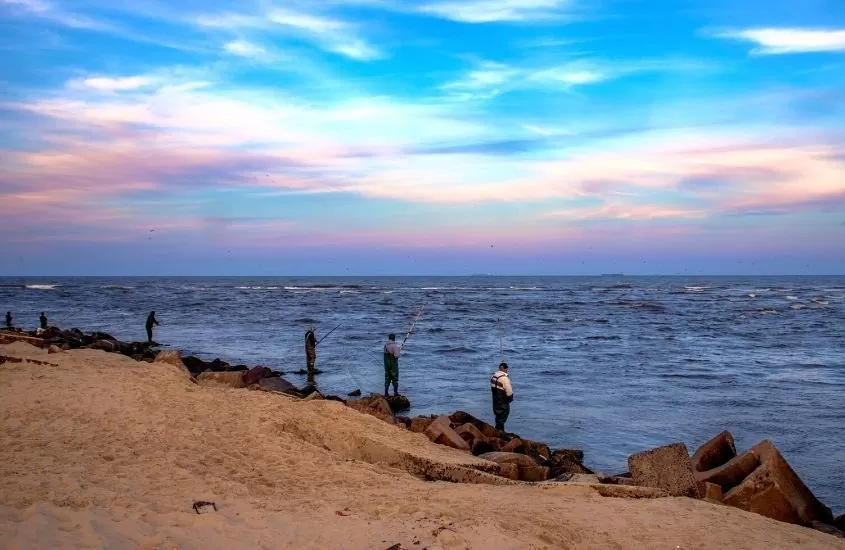 pescadores em frente ao mar de praia de imbé, durante o entardecer