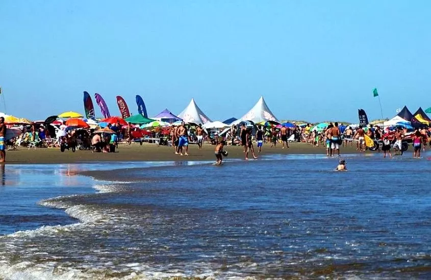 durante o dia, pessoas em areia e mar de praia do cassino, uma das praias no rio grande do sul