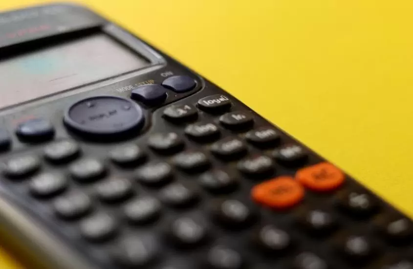 calculadora preta em cima de mesa amarela