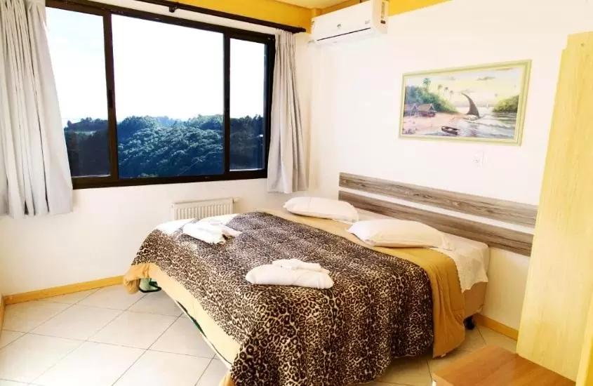 travesseiros e toalhas de banho brancas em cima de cama de casal em suíte de Hotel Bemtevi