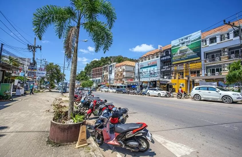 motos e carros estacionados em rua de Krabi Town, durante o dia