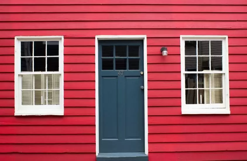 casa vermelha com janelas brancas e porta azul