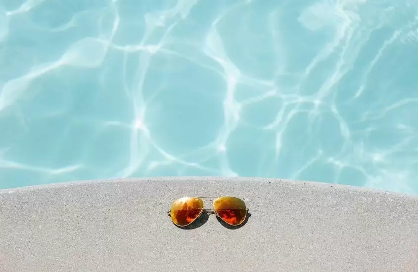 Óculos de sol na beira da piscina