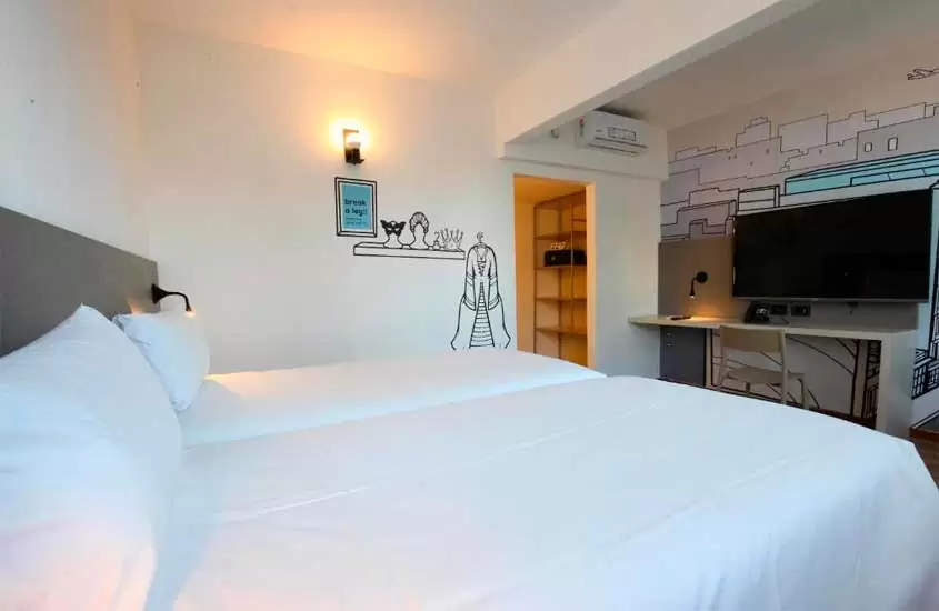 Quarto de hotel em Buenos Aires, com camas, TV, área de trabalho, ar-condicionado e armário aberto