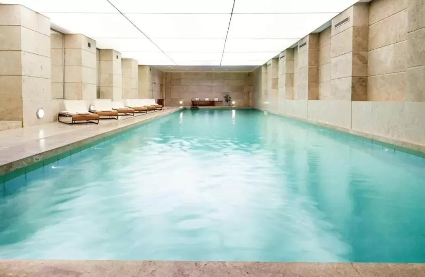 espreguiçadeiras em frente a piscina, em área de lazer coberta de Palacio Duhau, um dos melhores hotéis em buenos aires para lua de mel