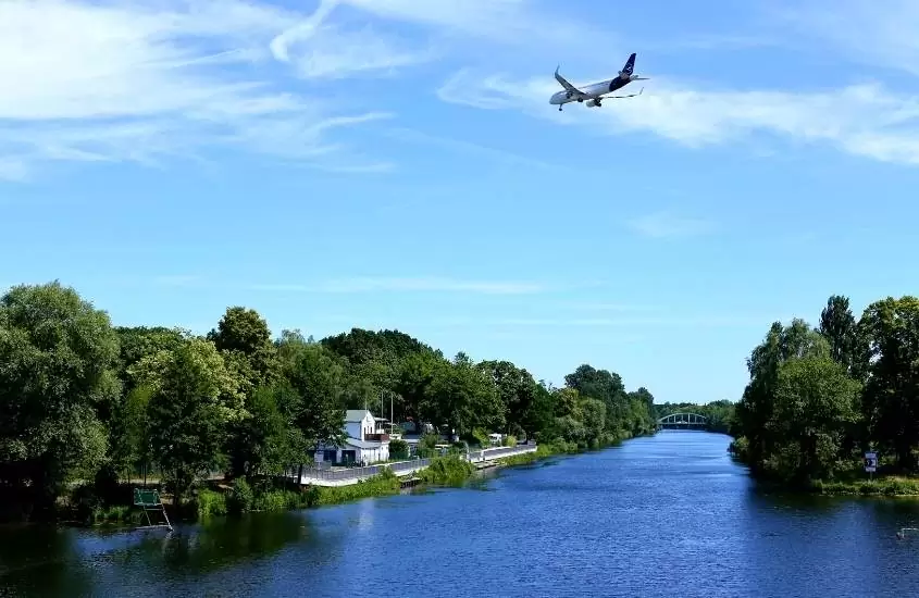 avião sobrevoando rio, durante o dia em viagem para berlim