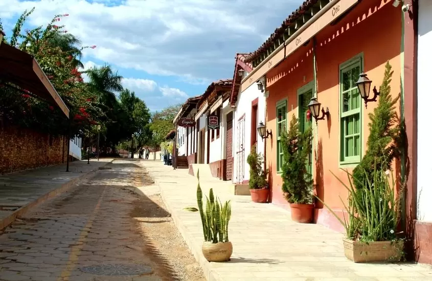 vasos de plantas em frente a casas coloridas, durante o dia, em rua de pirenópolis, um destino em goiás