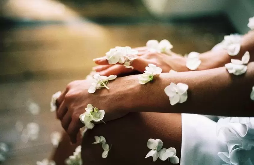 pétalas brancas de flores espalhadas em mão, braço e perna de pessoa sentada em um dos spas na alemanha