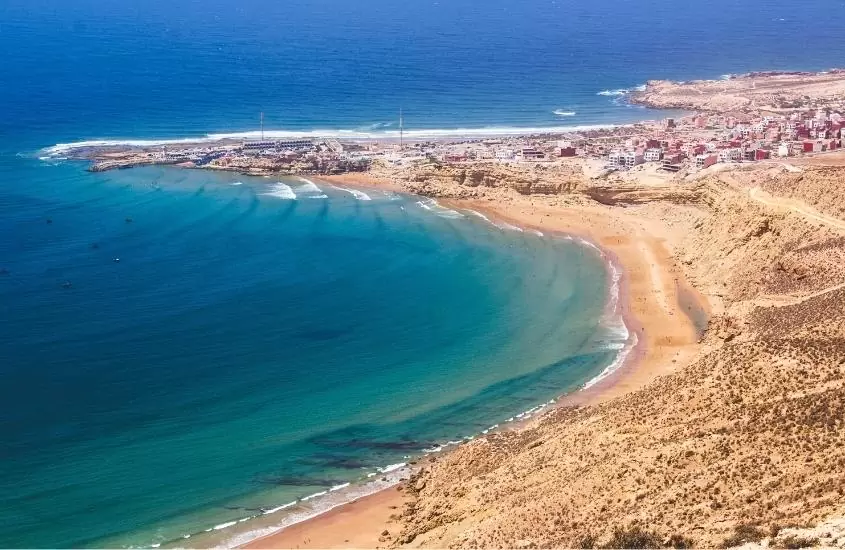 vista aérea de areia e mar, durante o dia em praia de agadir, atração para quem busca o que fazer no marrocos