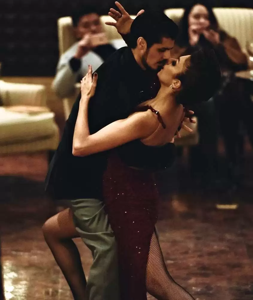 homem, de terno preto e mulher, de vestido vermelho, dançando tango, estilo musical da cultura da Argentina