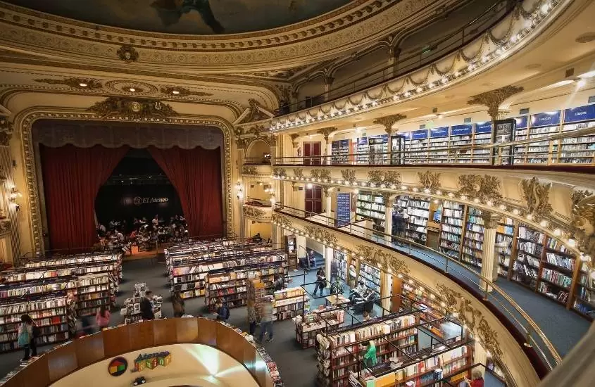 vista de alto de pessoas caminhando entre prateleiras cheias de livros em uma das bibliotecas de buenos aires que é um dos pontos turísticos da Argentina