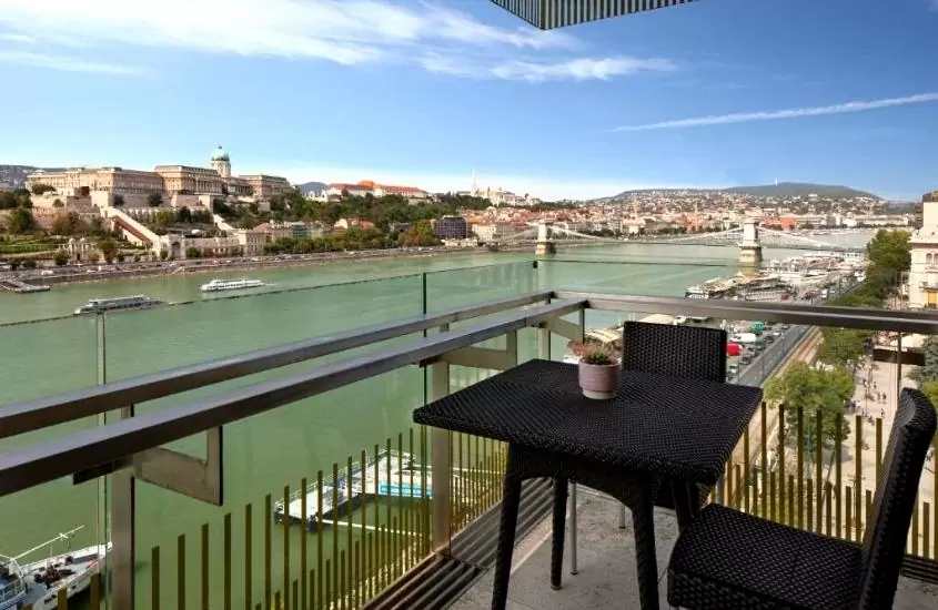 cadeiras ao redor de mesa em varanda com vista panorâmica para o rio danúbio em um dos melhores melhores hotéis em budapeste