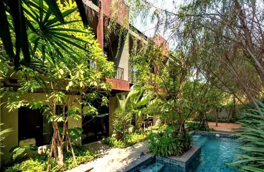 durante o dia, piscina cercada de árvores em um hotel onde ficar em Chiang Mai