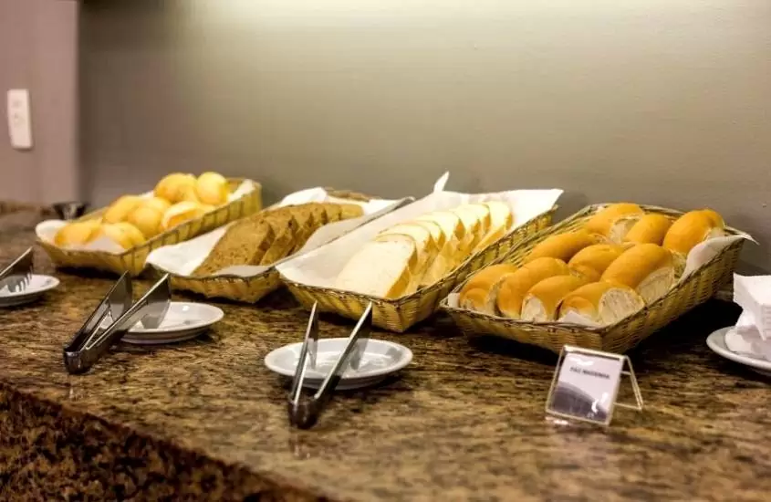 diversos pães em cima de mesa de refeitório de um dos melhores hoteis em porto alegre