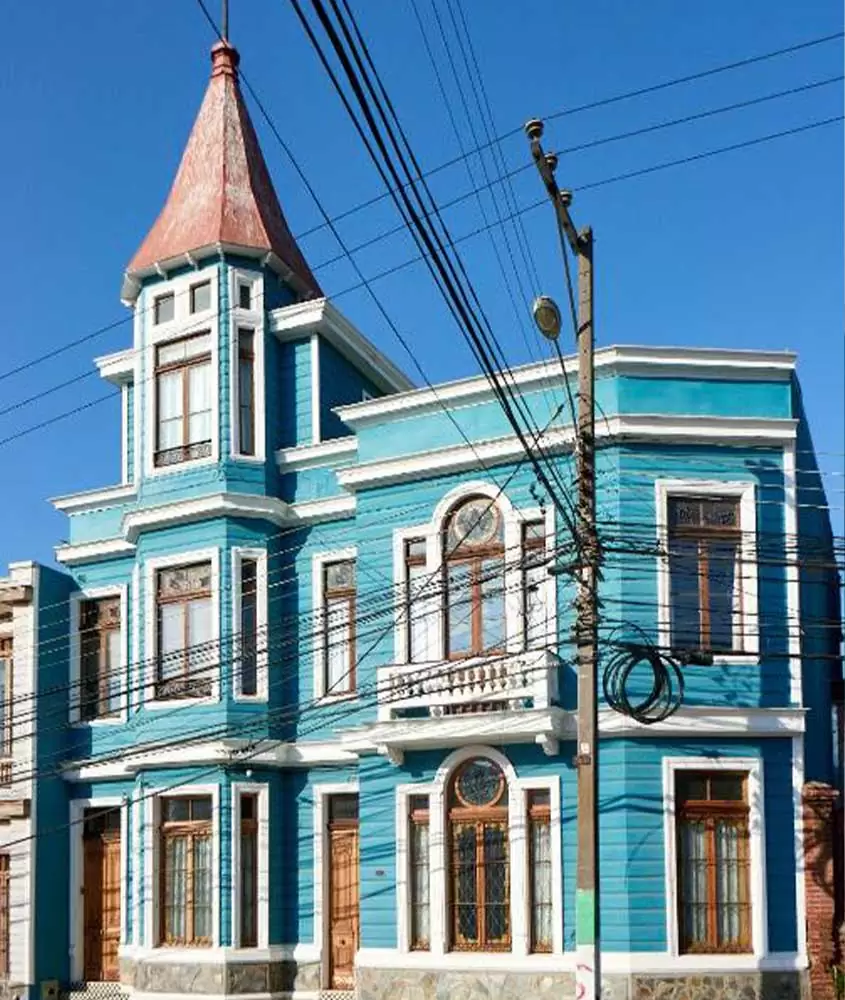 durante o dia, construção de 3 andares azul e branca, com janelas brancas e marrons em rua de valparaíso, local para turismo no chile