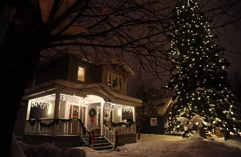 durante a noite, árvore de natal em frente a casa cinza