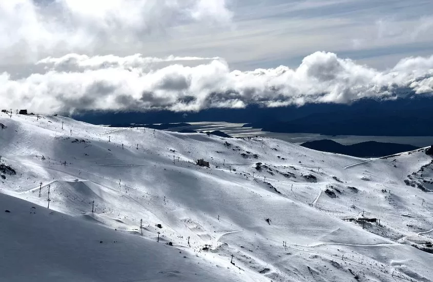 durante dia nublado, montanhas de neve em estação de esqui, para quem busca o que fazer em bariloche em agosto
