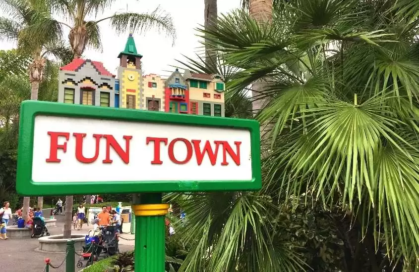 durante o dia, letreiro onde há escrito 'fun town', ao fundo, construções de lego coloridas