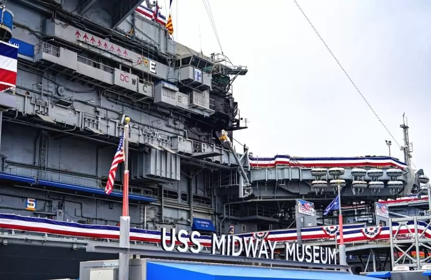durante o dia, navio porta-aviões cinza, com letreiro escrito 'uss midway museum'