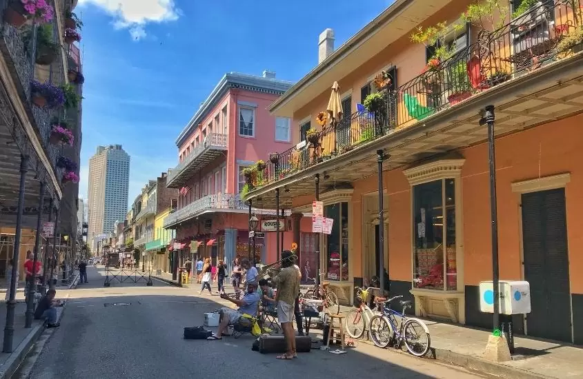 durante o dia, músicos se apresentando em rua cercada de construções coloridas em french quarter, bairro para turismo nos estados unidos