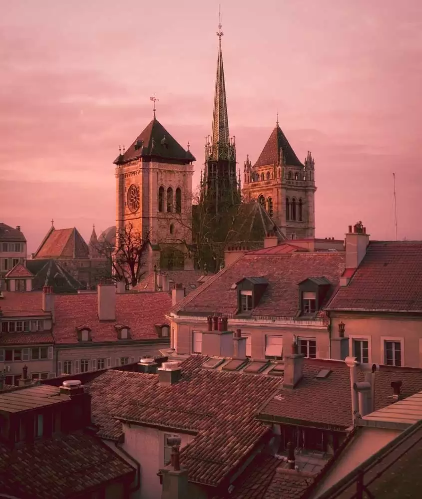 durante entardecer, telhado de casas e igrejas sob céu rosa na cidade velha, lugar onde ficar em Genebra