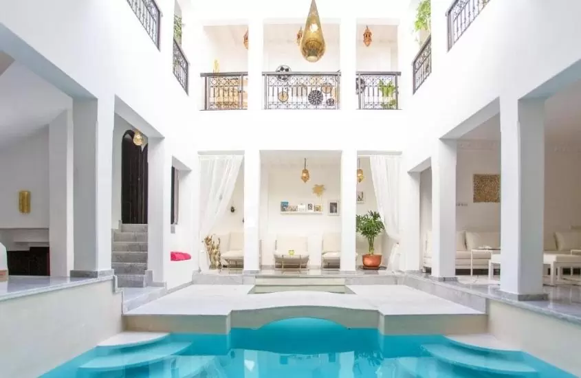 durante o dia, piscina em centro de pátio de riad em marrakech com paredes brancas