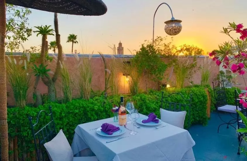 durante entardecer, mesas e cadeiras em restaurante ao ar livre de um dos melhores riads em marrakech