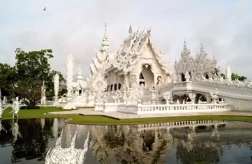 durante o dia, lago em frente a templos brancos de chiang rai, destino para um roteiro de viagem tailândia