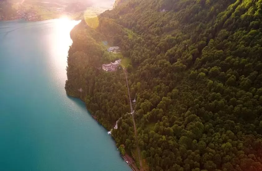 durante o dia, vista aérea de casa em topo de montanha à beira de lago