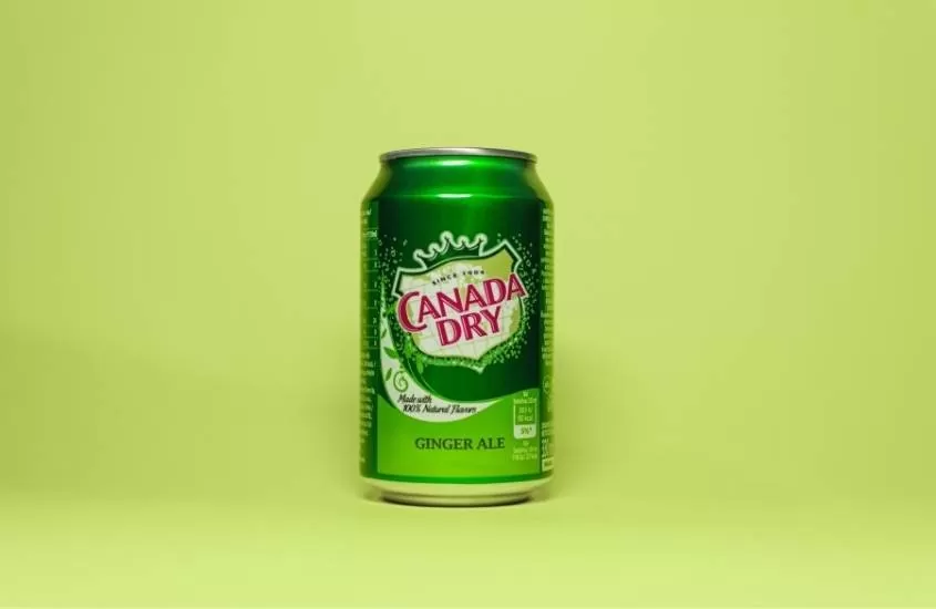 lata verde de refrigerante ginger ale, uma das bebidas típicas do Canadá, em fundo verde