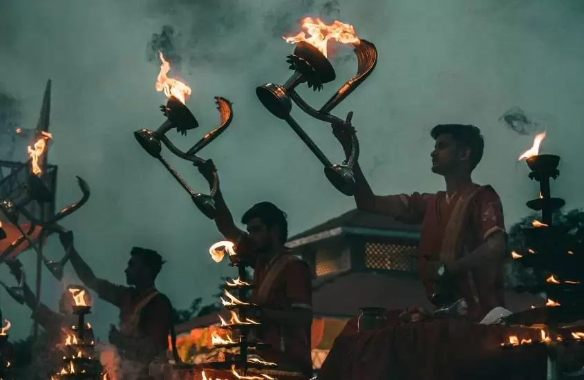 durante a noite, pessoas segurando tochas de fogo em varanasi, destino de viagem para Índia