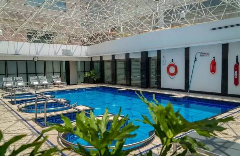 durante dia ensolarado, espreguiçadeiras em frente a piscina de hotel em um dos lugares no México