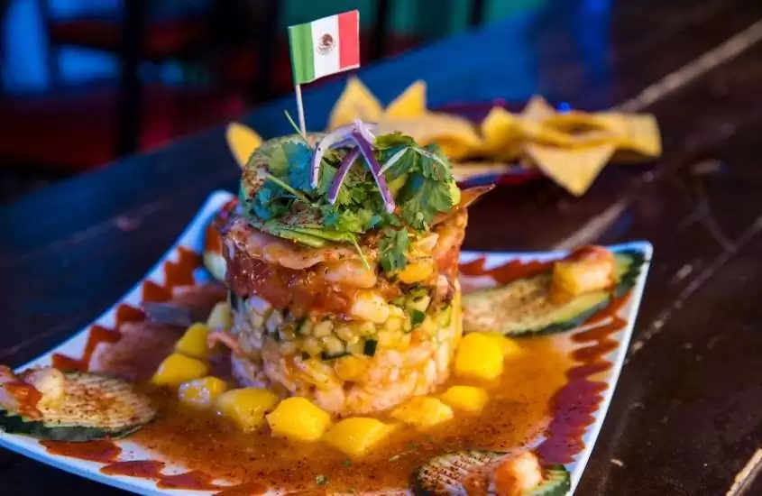pequena bandeira do méxico em cima de uma das comidas mexicanas que, segundo curiosidades sobre o México, é patrimônio cultural